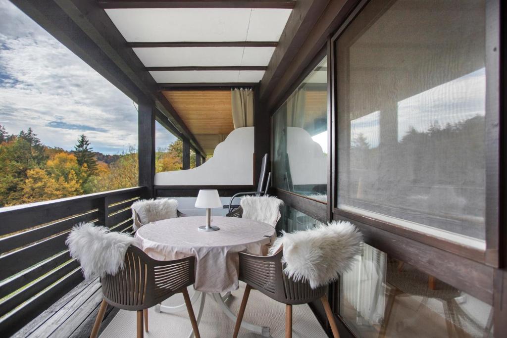 a room with a table and chairs on a balcony at Haus Seidelbast in Siegsdorf
