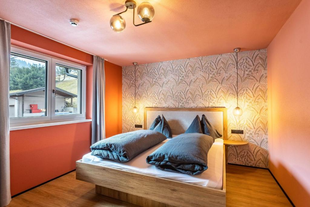 a bedroom with a bed with two pillows and a window at Luisalle Top 4 in Auffach