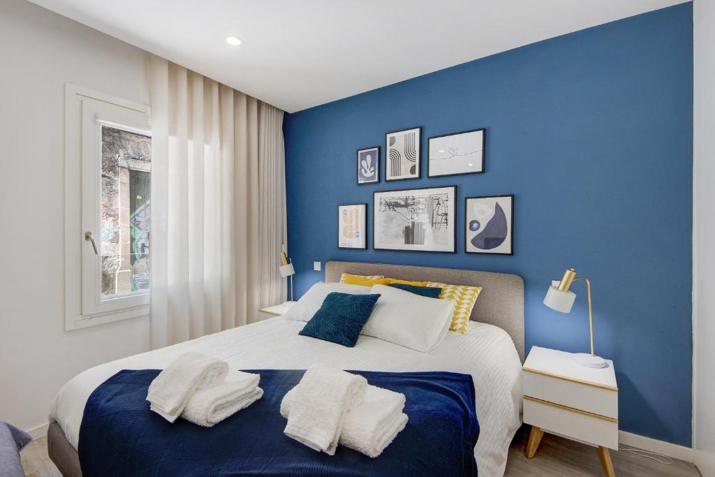 a blue bedroom with a bed with towels on it at Aveiro City Blue in Aveiro