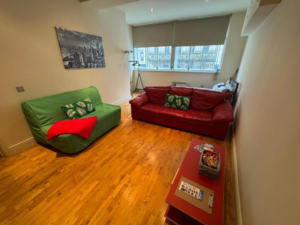 a living room with a red couch and a green chair at Cardiff City Escapes in Cardiff