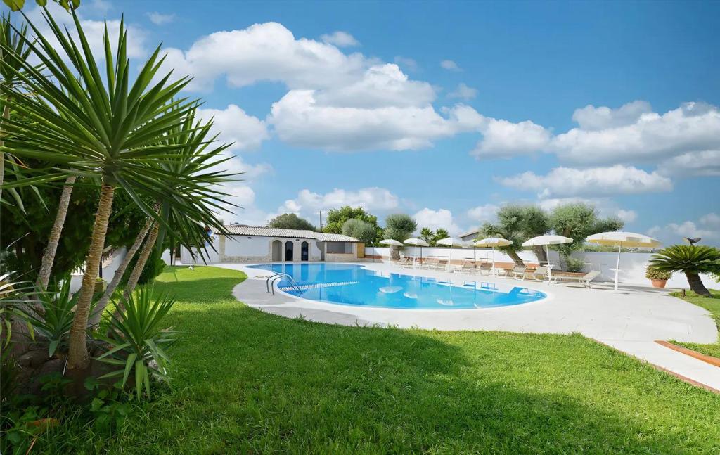 a swimming pool in a yard with a palm tree at Villa Parisi con piscina in Syracuse