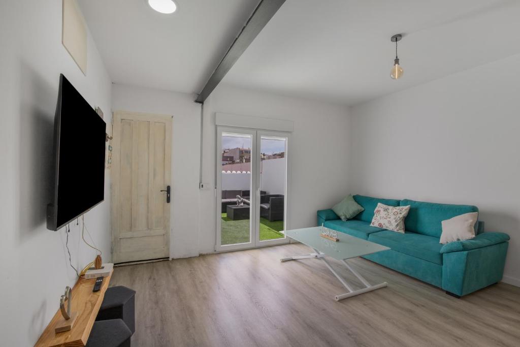 a living room with a blue couch and a tv at Casa Us in Arinaga