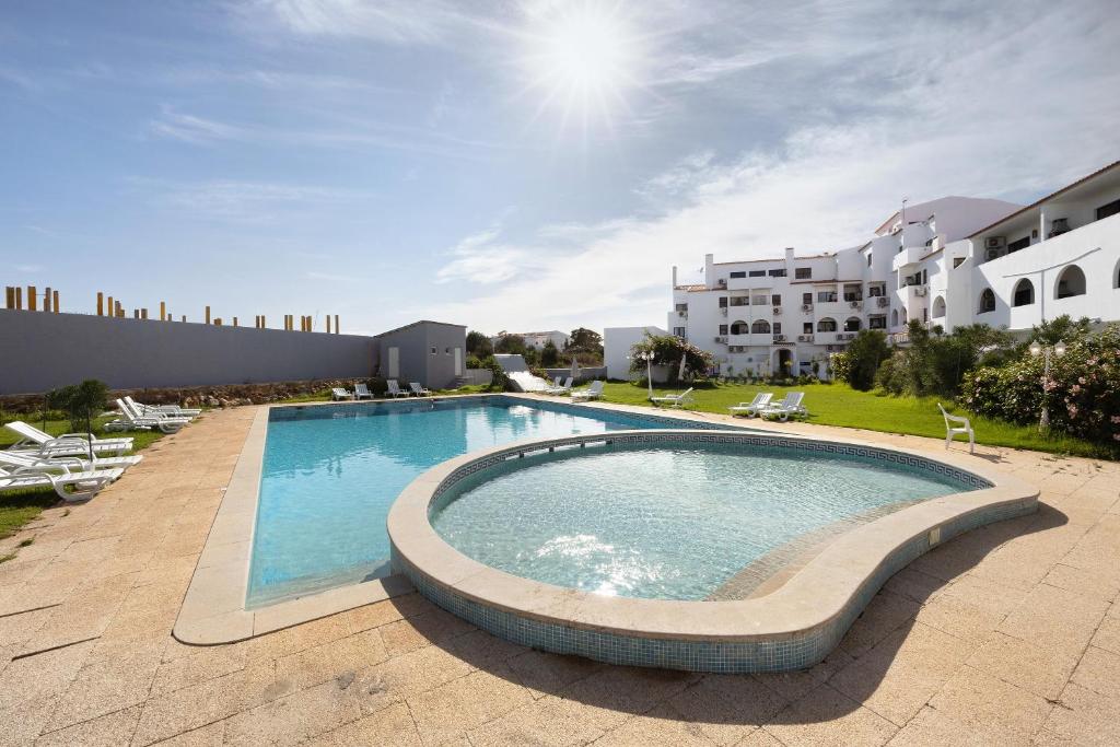 a large swimming pool in front of a building at Yasmim House in Sagres