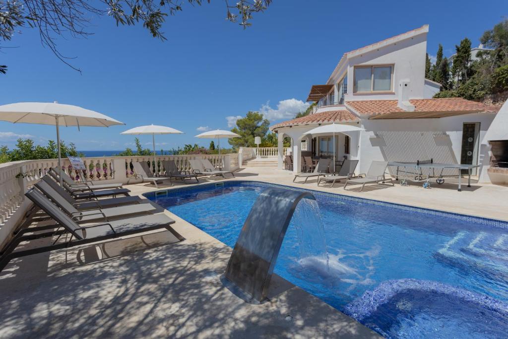 a villa with a swimming pool and a house at Villa Maitreya in Son Bou