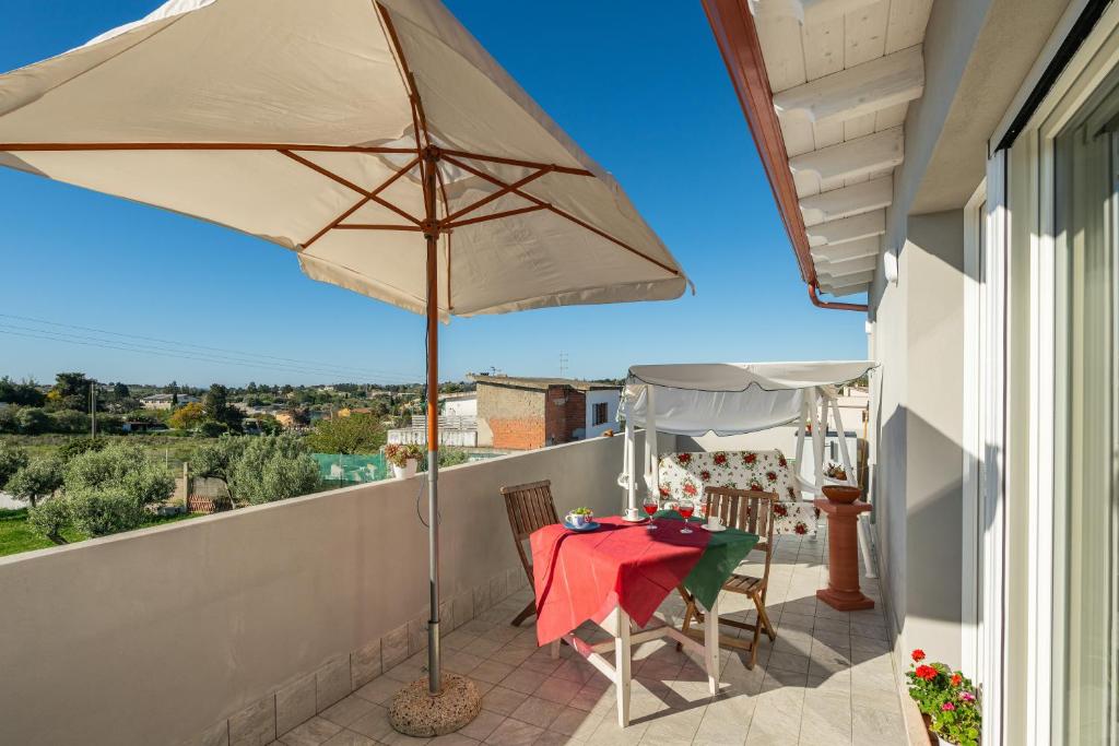 a patio with a table and an umbrella at Moon - Rooms in Quartu SantʼElena