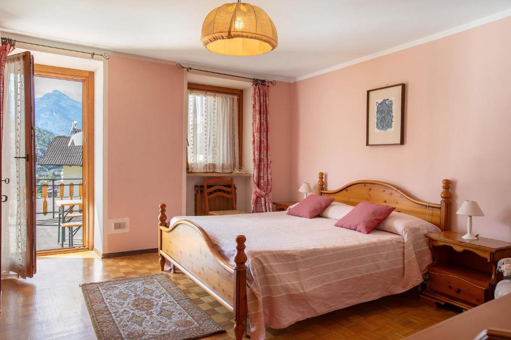 a bedroom with a bed with pink walls at Il Borgo - Aymavilles in Aymavilles