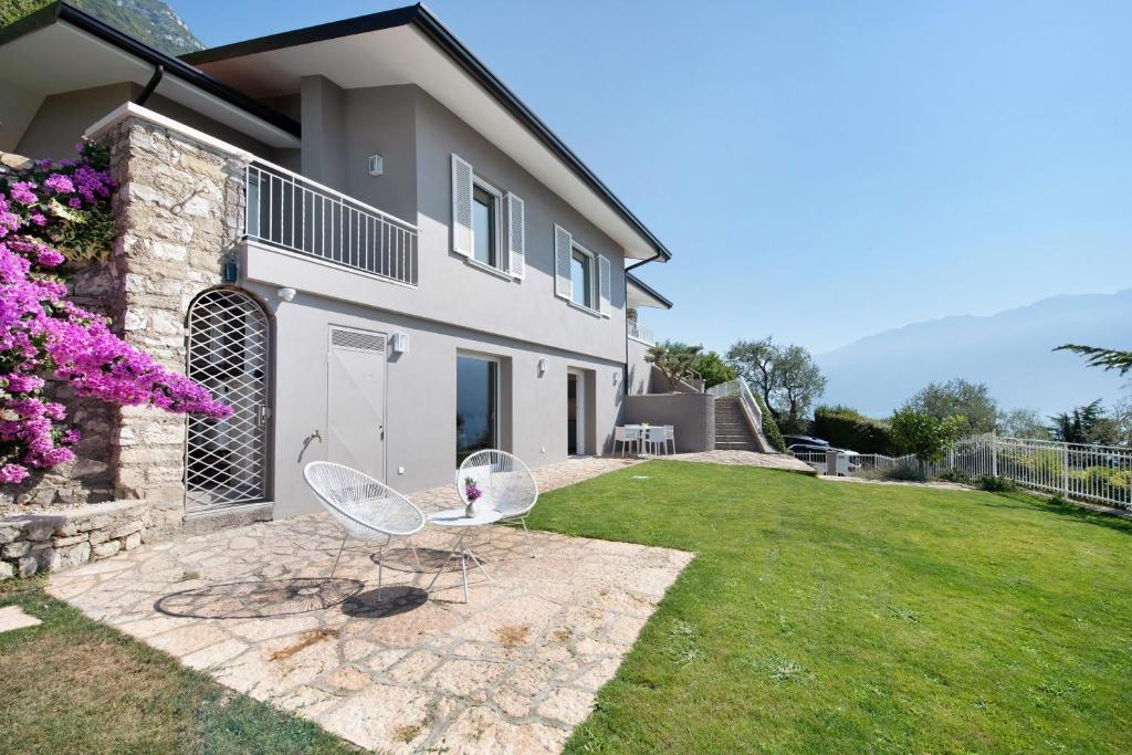 a house with two chairs in the yard at Villa Gargnano in Gargnano