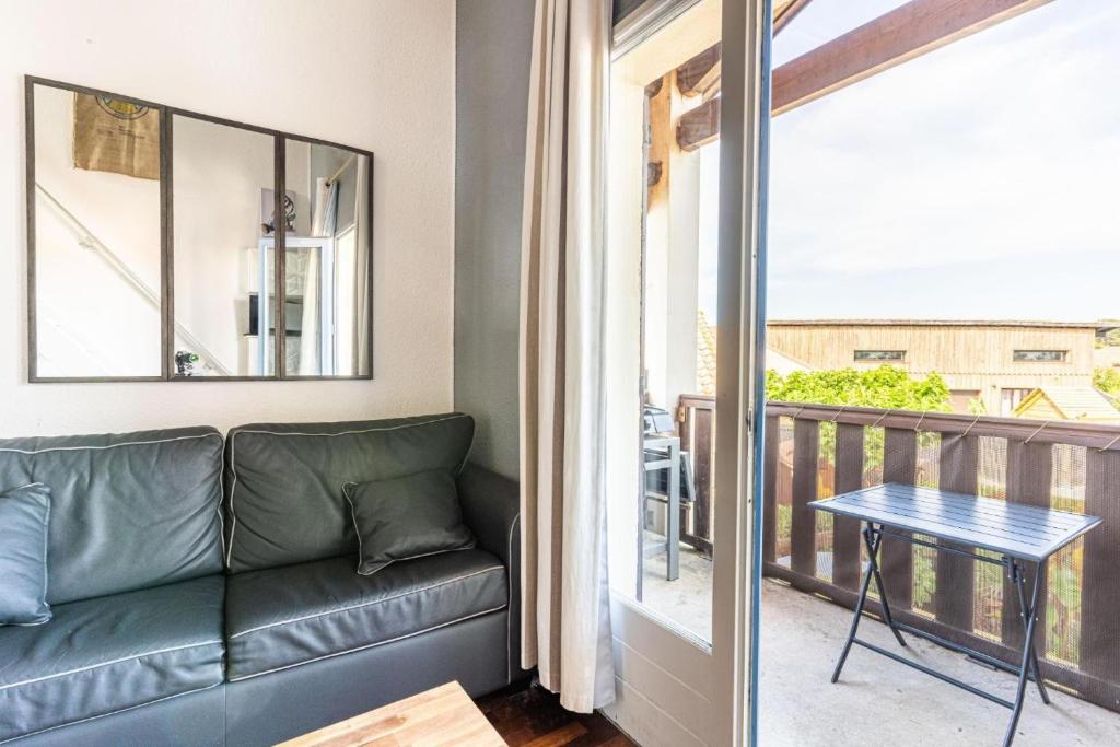 a living room with a couch and a balcony at Charmant Studio Mezzanine in Biscarrosse