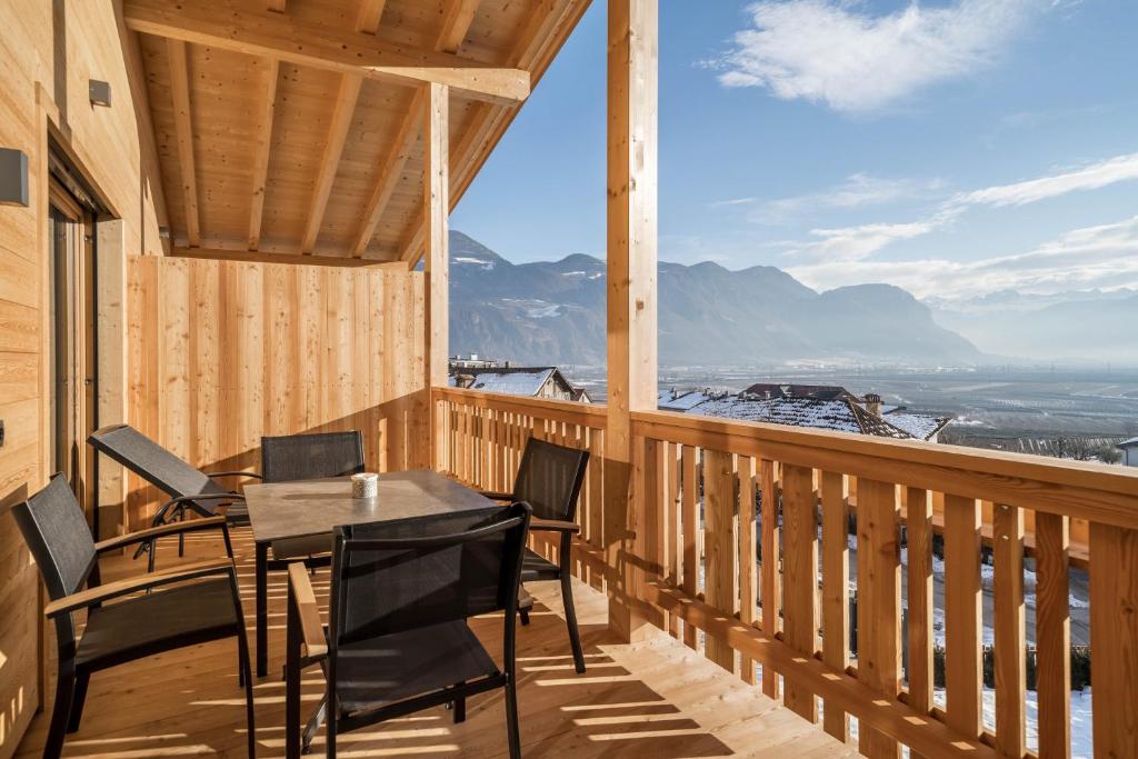 a balcony with a table and chairs and mountains at Apt Zirbe - Nockerhof in Andrian