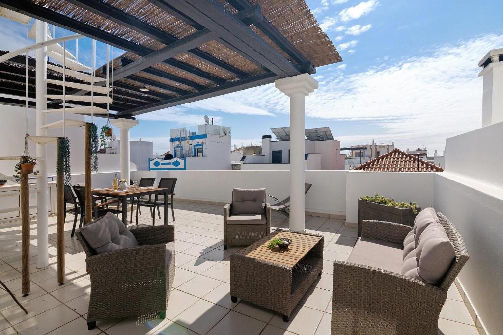 a patio with chairs and a table on a roof at Ria's Birds in Cabanas de Tavira