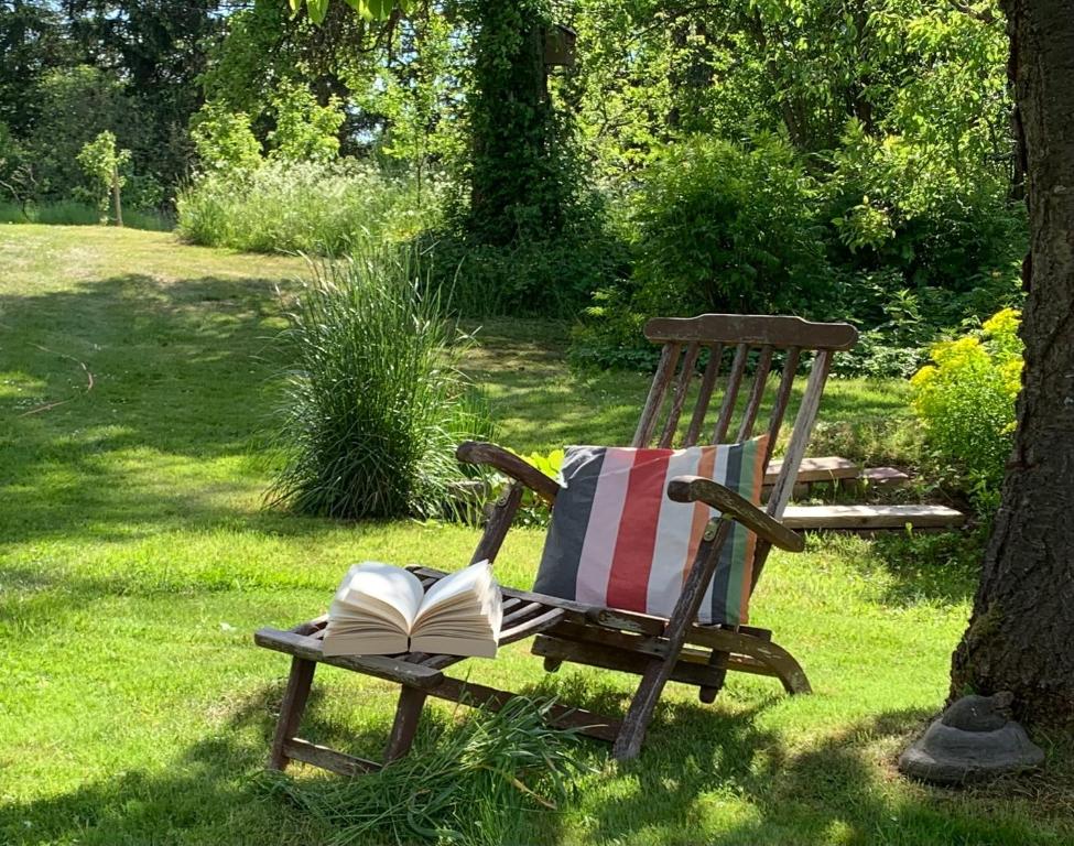 a wooden chair with an open book in the grass at Das Sommerhaus in Zülow