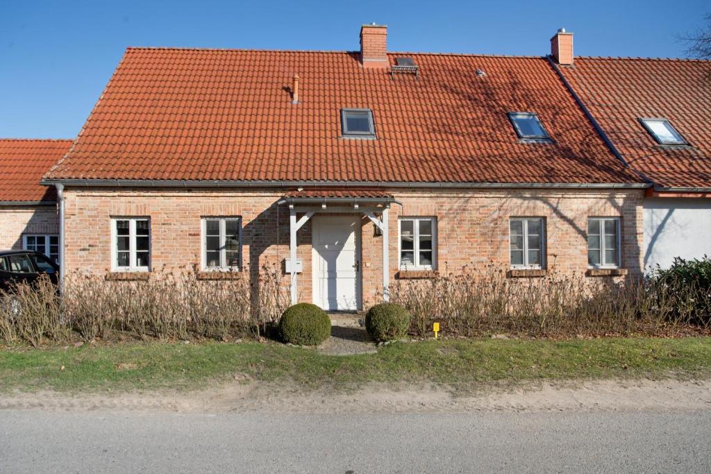 an old brick house with a red roof at Haus Herr Krug in Walkendorf