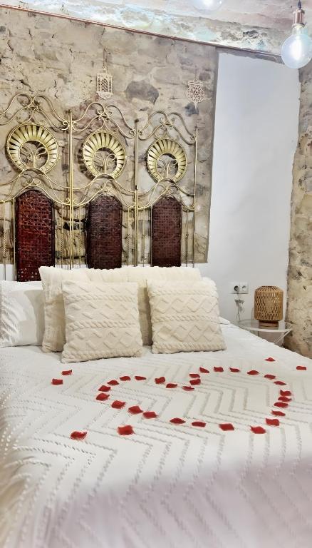 a bed with red roses on top of it at La Casa Arabe in Alcalá de los Gazules