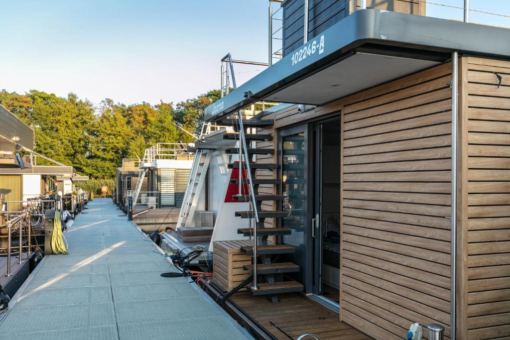 a small building with a staircase next to a boat at Hausboot Joana in Zehdenick