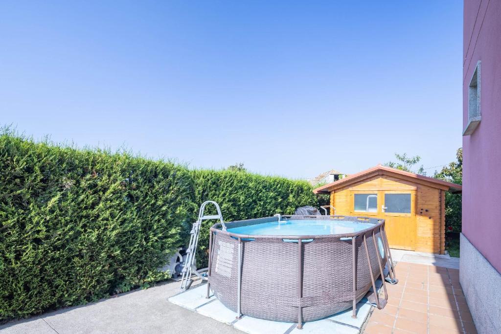 a hot tub on a patio next to a hedge at Almar in Vigo