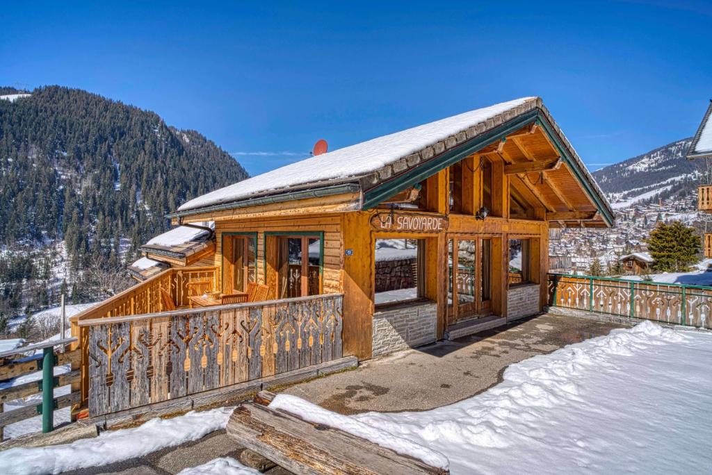 a large wooden house with a balcony in the snow at Chalet la savoyarde in Châtel