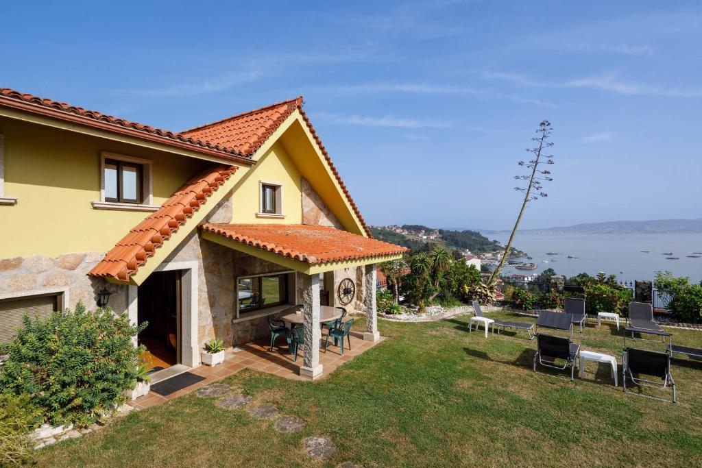 a house with a yard with chairs and a table at Casa Nueva de Bueu in Bueu