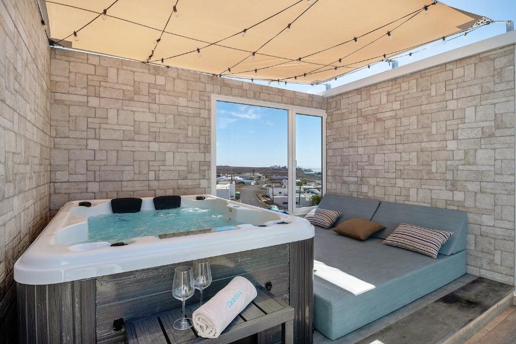 a bath tub in a room with a large window at Casa Mara 2 in Playa Quemada