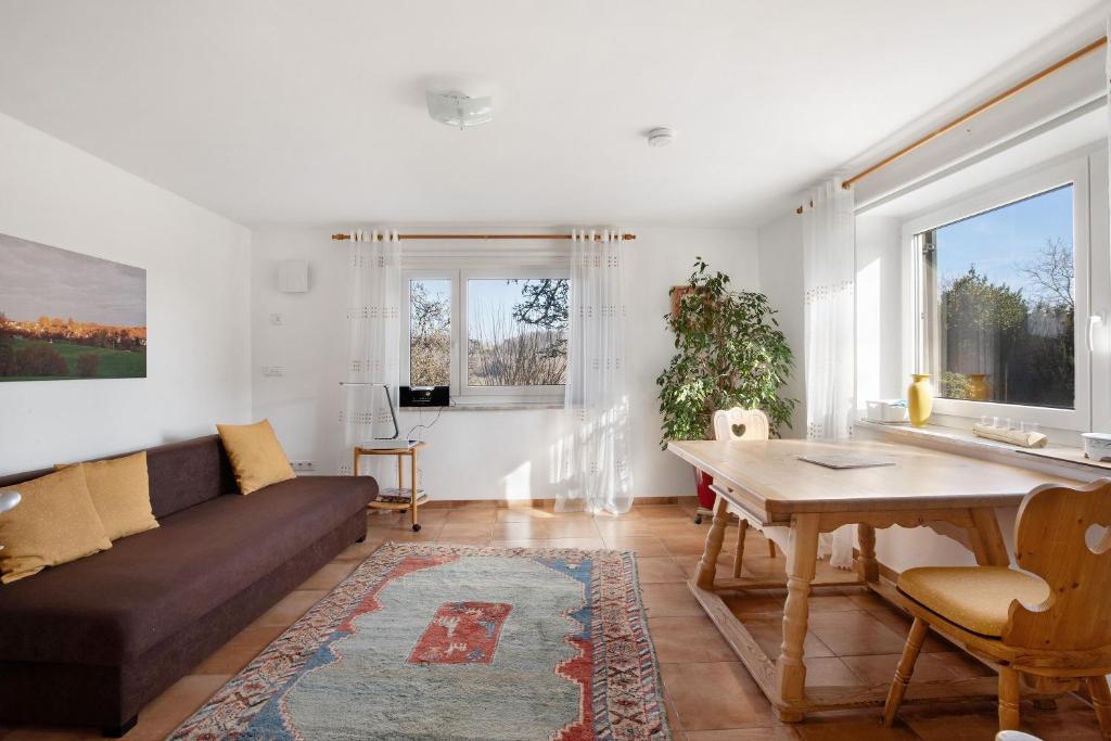a living room with a couch and a table at Birkethof Teichblick in Grimoldsried