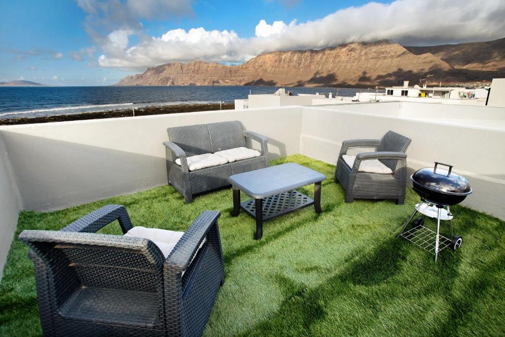 a patio with chairs and a grill on the grass at Casa Vivo in Famara