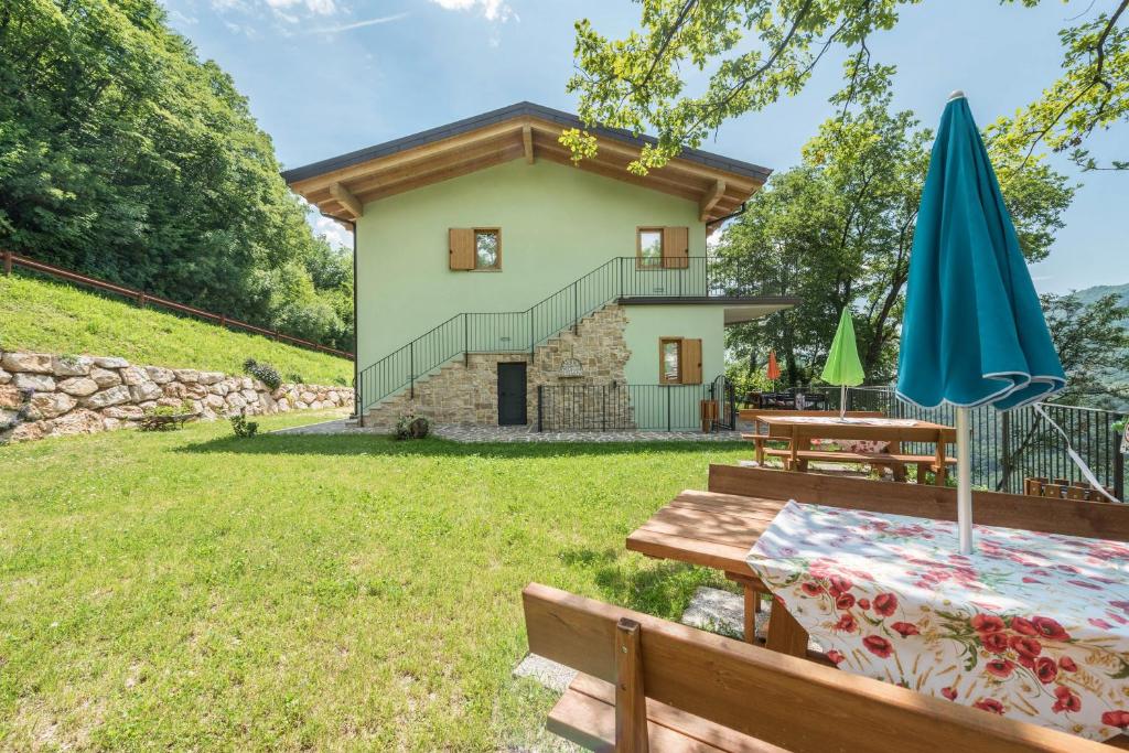 a cottage with a picnic table and an umbrella at Nonno Bigi Girasole in Tremosine Sul Garda