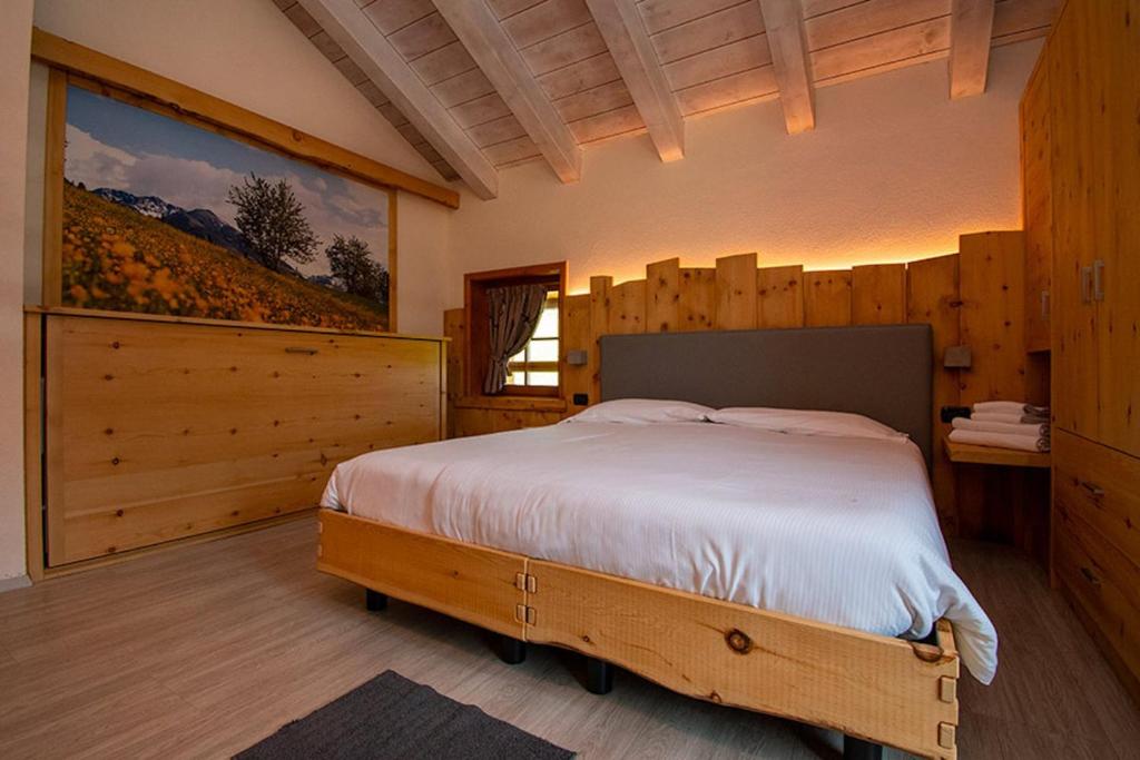a bedroom with a bed in a room with wooden walls at Chalet Galli Trilocale in Livigno