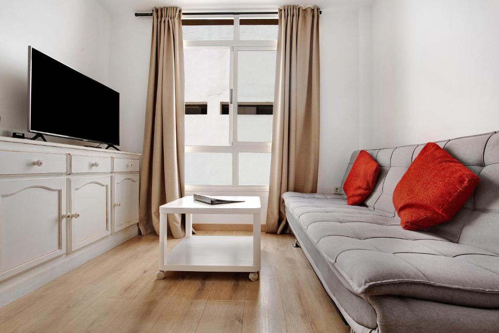 a living room with a couch and a tv at Apartamento Playa Morro Jable 1a in Morro del Jable