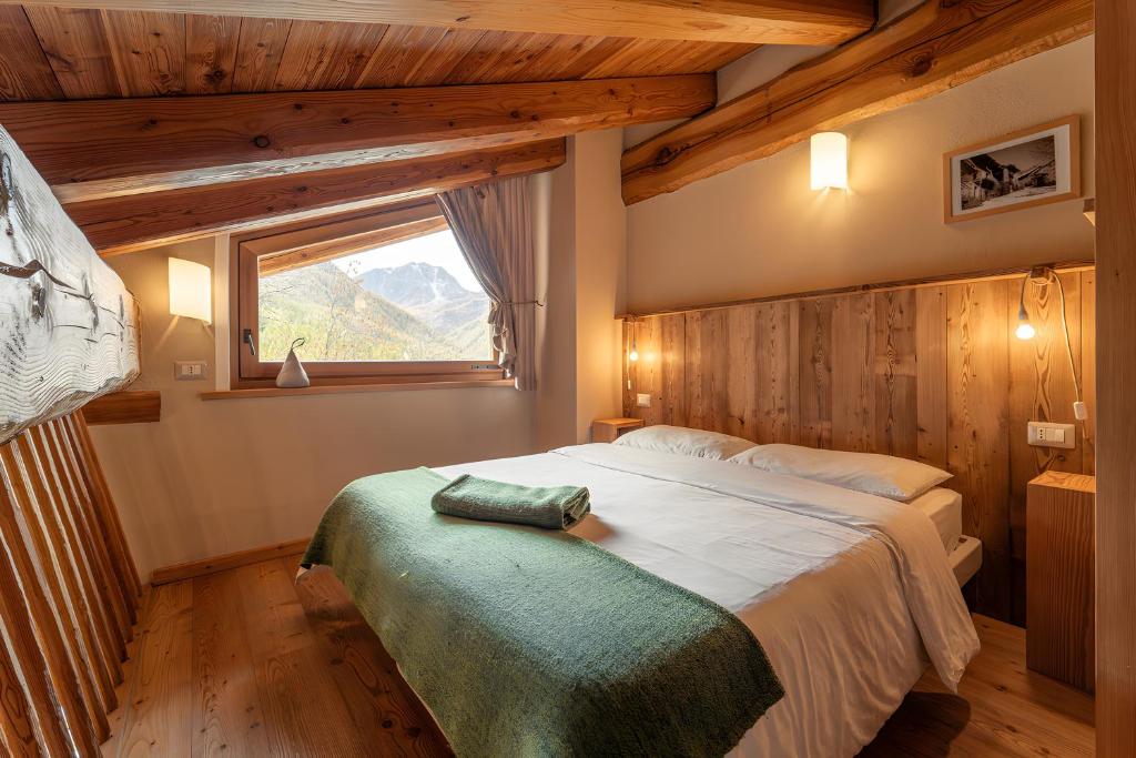 a bedroom with a large bed with a window at Civico 1 in Marmora