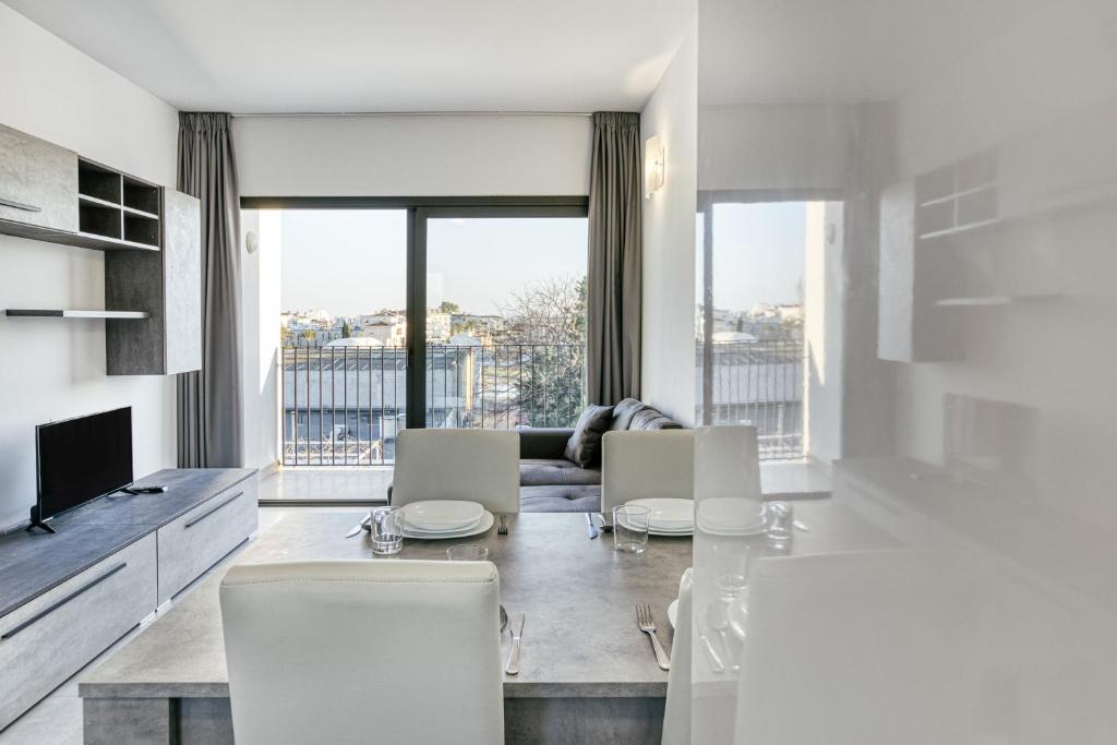 a white living room with a table and chairs at Giuliano Superior 1 para 4 personas in Empuriabrava