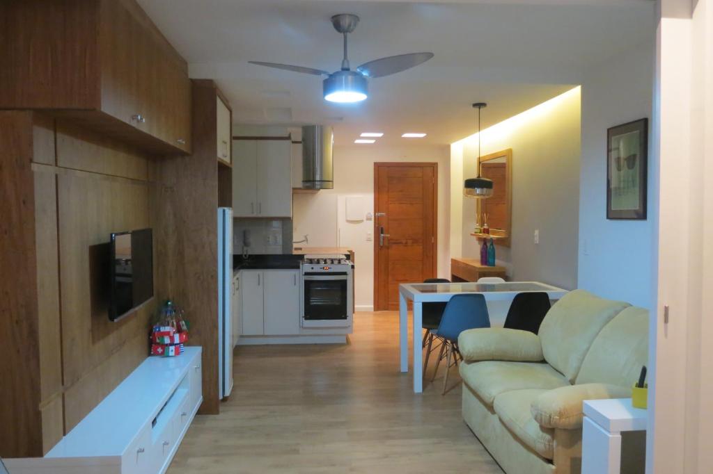 een woonkamer en een keuken met een bank en een tafel bij Loft Felipe De Oliveira in Rio de Janeiro