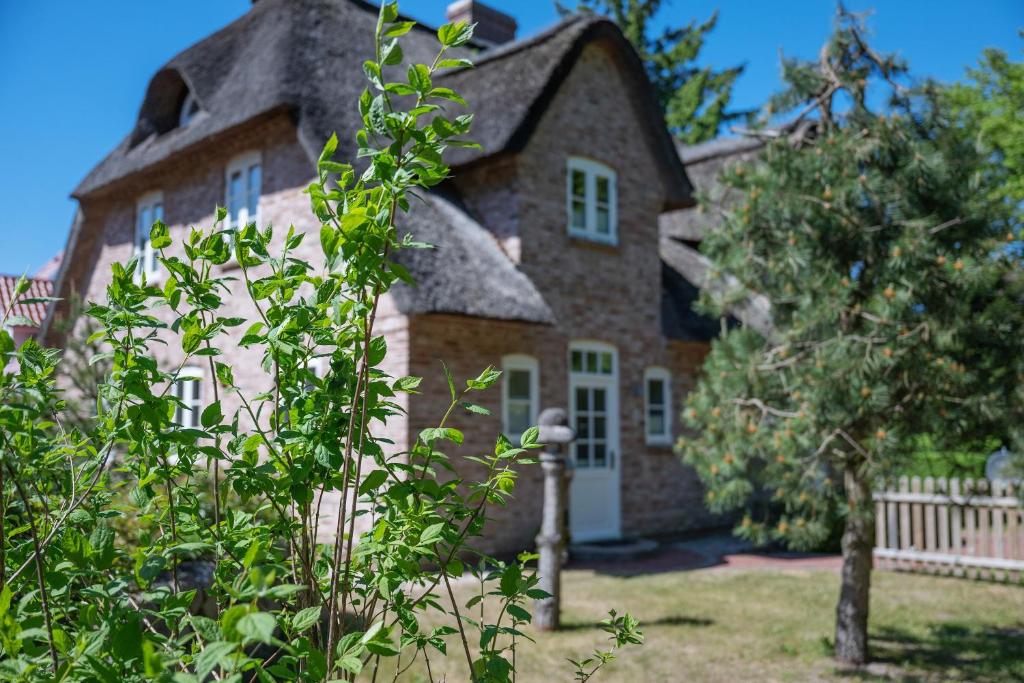 a large brick house with a thatched roof at Ferienhaus Huus Alex in Böhl