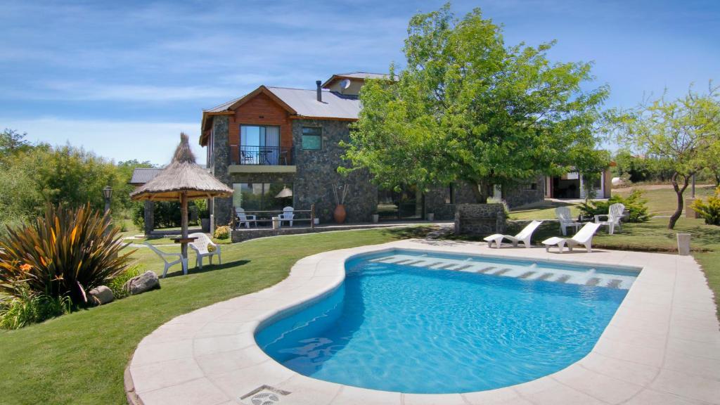 a house with a swimming pool in the yard at Melodias Posada Boutique in Los Reartes
