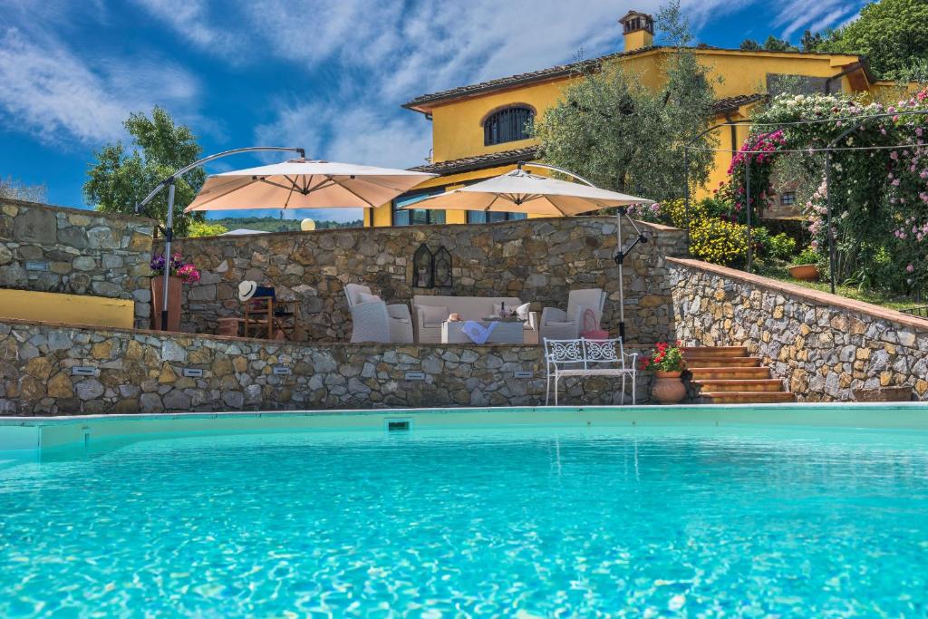 a villa with a swimming pool in front of a house at Podere Bucigattolo in Serravalle Pistoiese