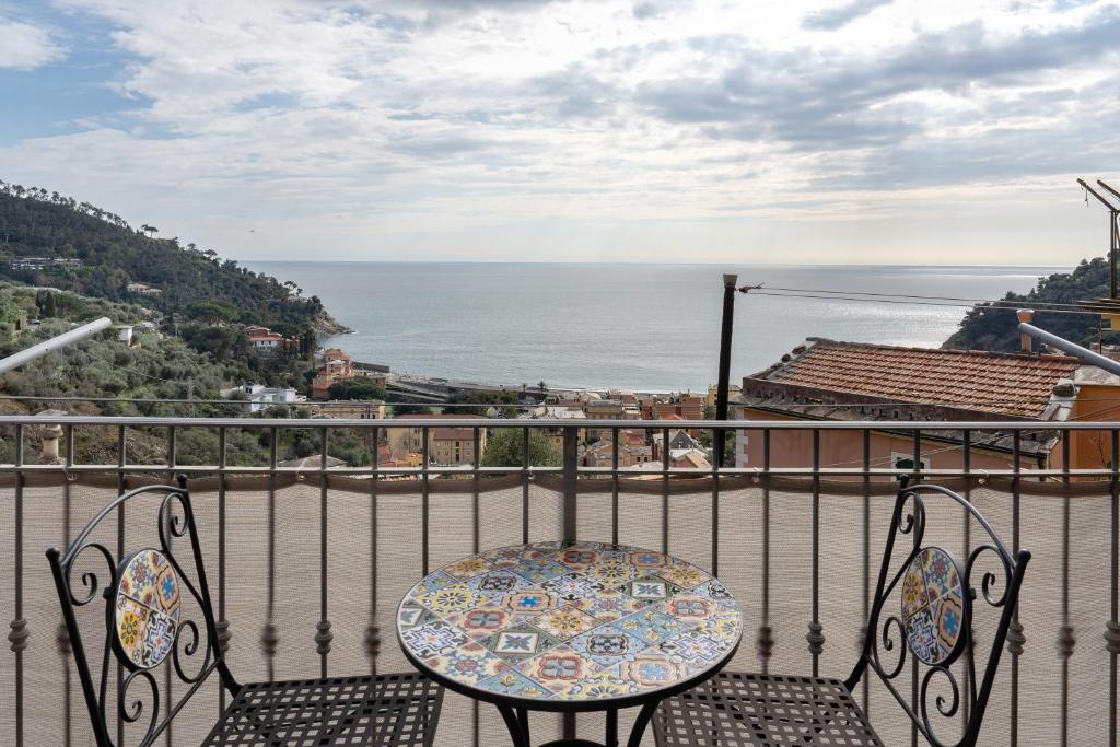 a table and chairs on a balcony overlooking the ocean at Profumo di Salsedine in Bonassola