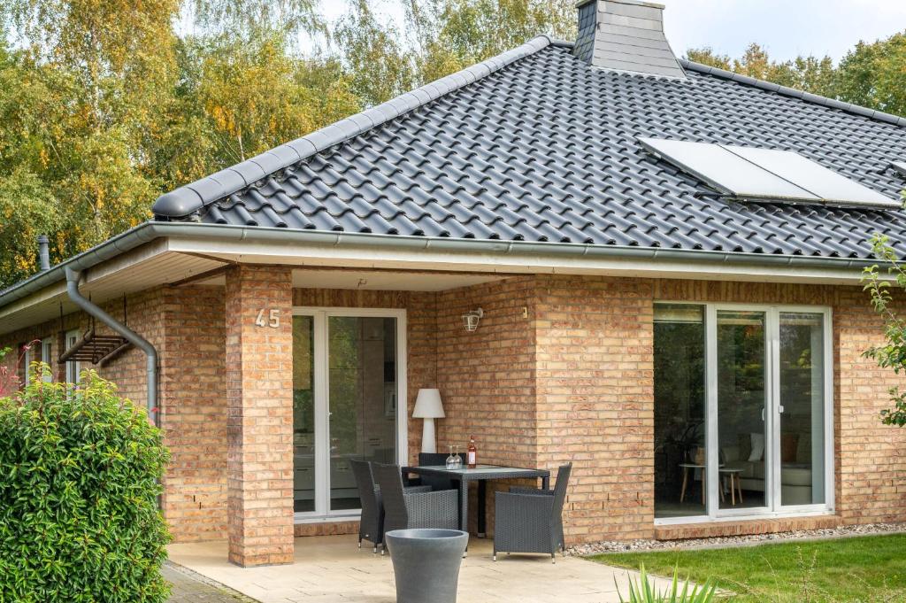 a house with a roof with a table on a patio at Großes Ferienhaus Im Grünen - in Dummerstorf
