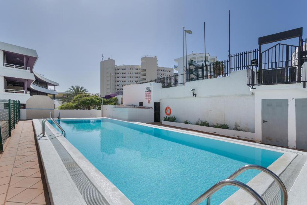 a swimming pool on the roof of a building at Apartamento Yumbo Centro in Maspalomas