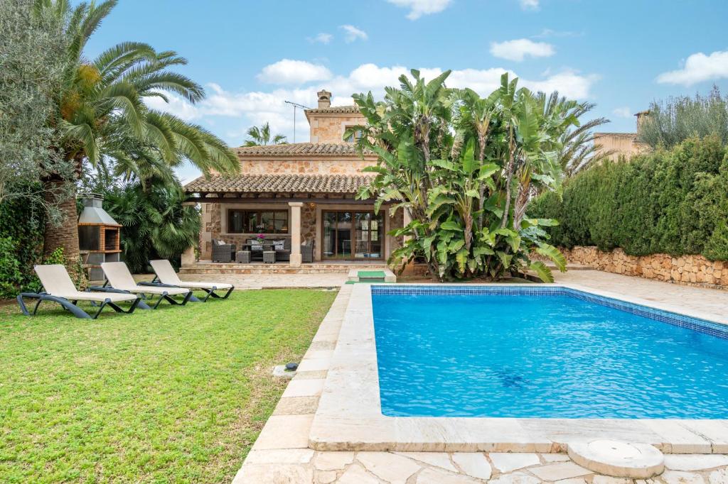 a villa with a swimming pool and a house at Casa Brava in Santanyi