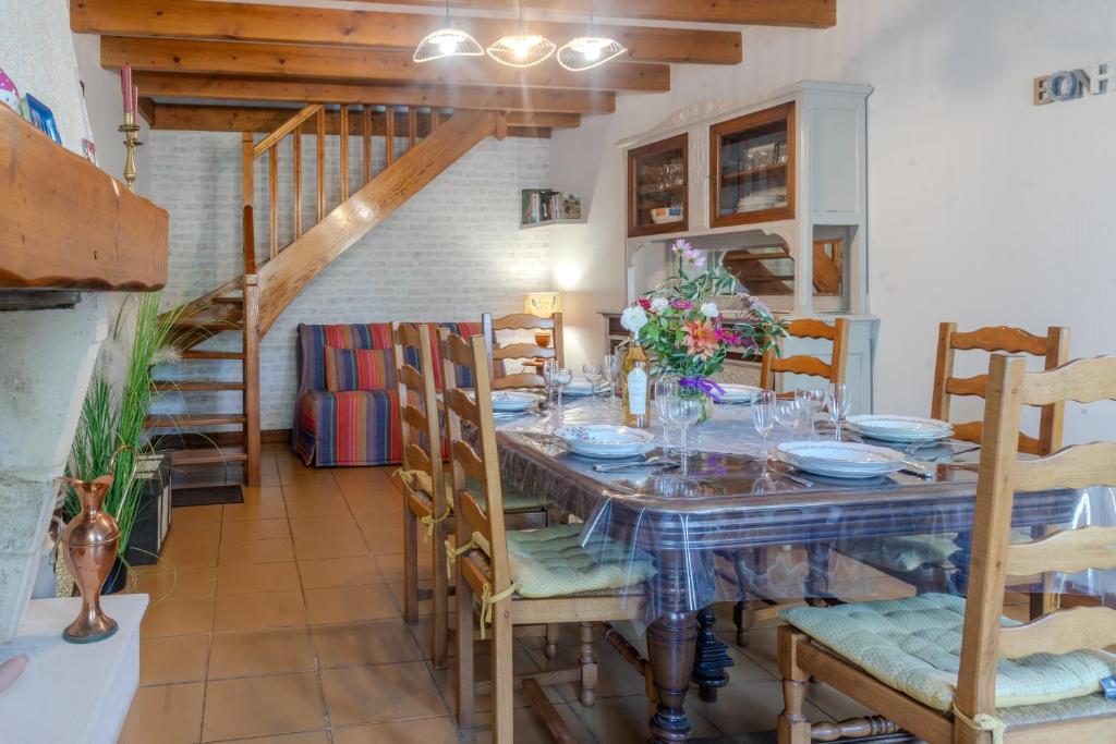 a dining room with a table and chairs and a staircase at Le Logis Chez Bompain in Brizambourg