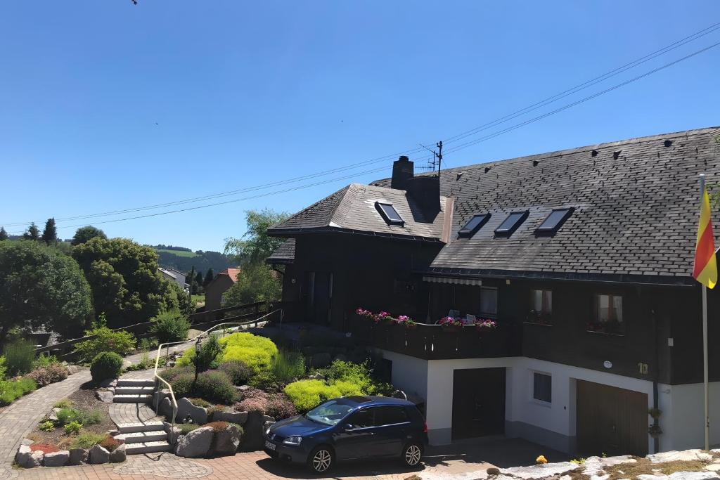 a black house with a car parked in front of it at Haus Jurisch in Urberg