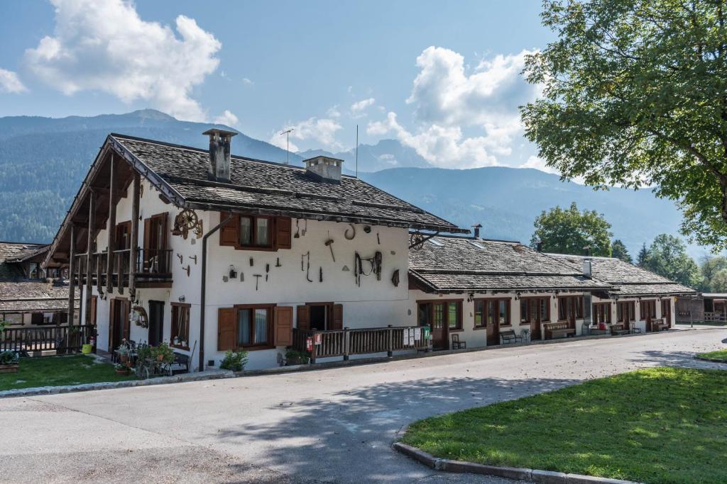 a large white building with mountains in the background at Appartamento Adamello 14 in Pinzolo