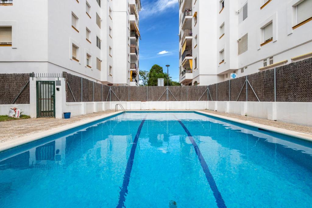 a swimming pool in the middle of two buildings at Oasis in Sitges