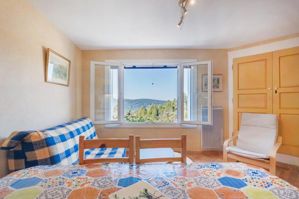 a living room with a table and a window at L'amourié, Rdc, Gîte 4 Personnes in Sainte-Croix-de-Verdon