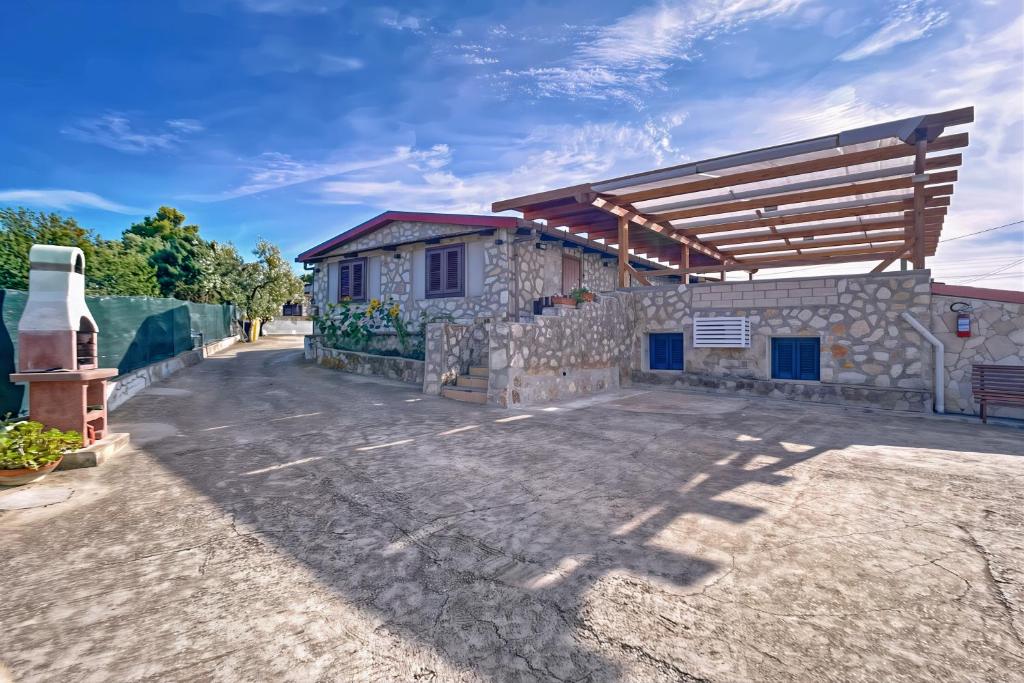 a house with a stone wall and a wooden roof at La Mignola - Casa Vacanze in Vieste