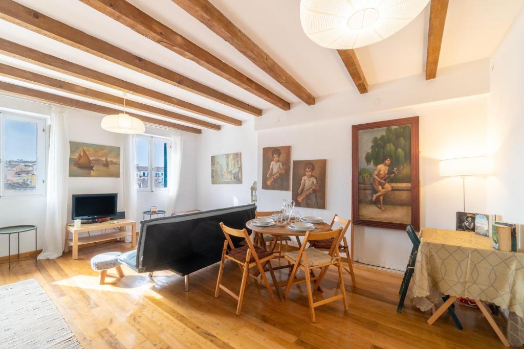 a living room with a table and chairs and a television at Contessa di Corfu ii in Corfu