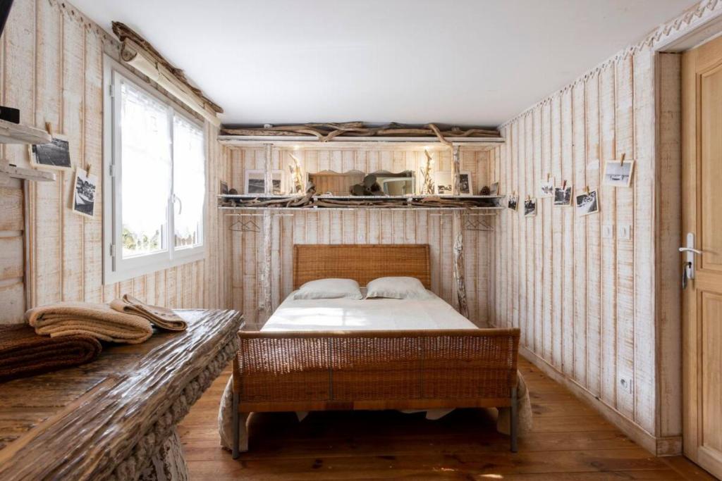 a bedroom with a bed in the corner of a room at La Cabane de Bébert - Marie en Lys in Cap-Ferret