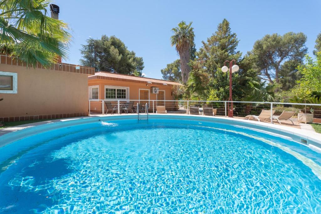 a large swimming pool in front of a house at Ilusion in Olocau