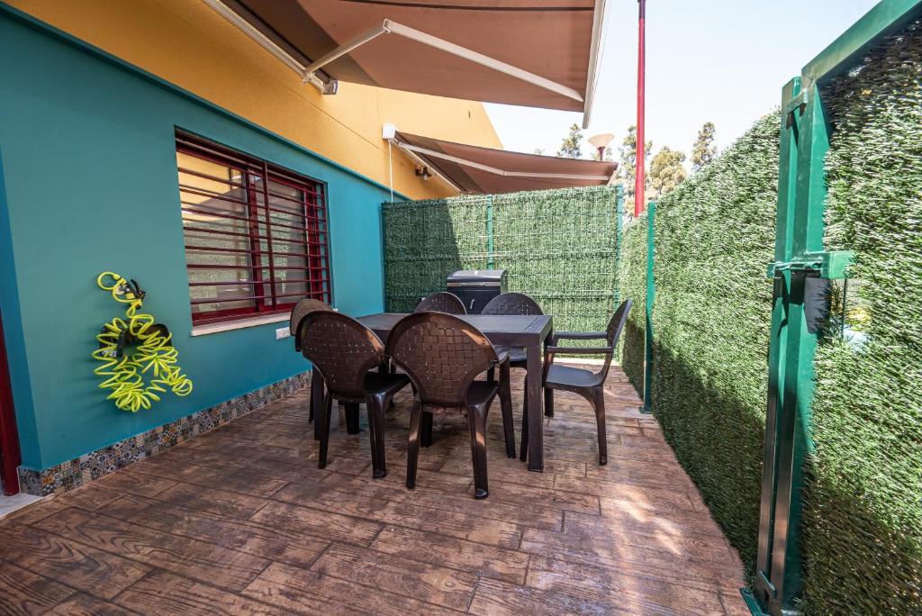 a table and chairs on a patio with a blue wall at Ocean Suites A4 in Isla Cristina