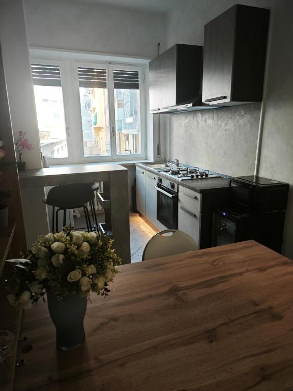 a kitchen with a wooden table with a vase of flowers at DeMarchi in Biella