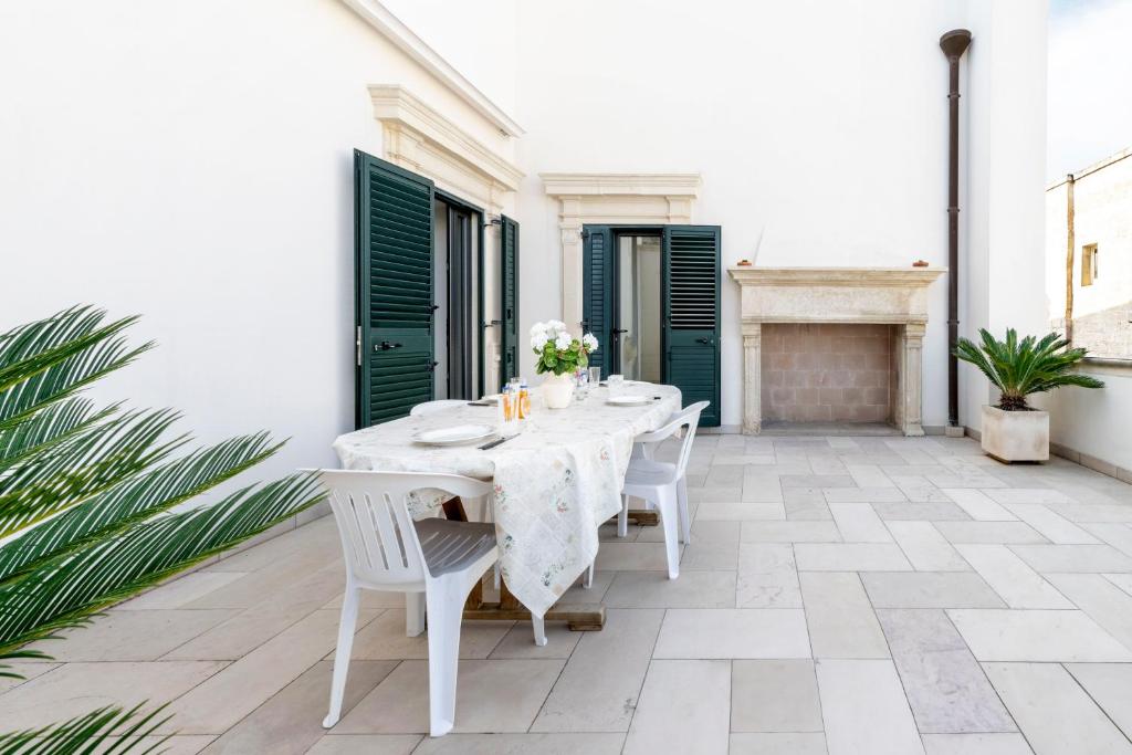 a white table and chairs on a patio at Casa Pizzicchia in Muro Leccese
