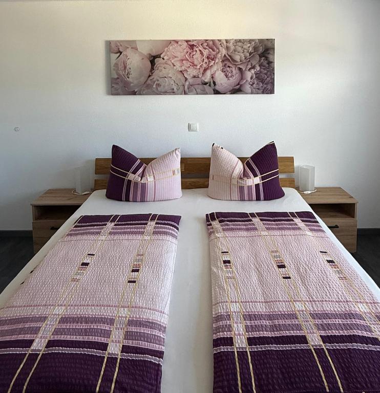 a bedroom with two beds with purple pillows at Ferienwohnung S Keller in Plankenfels